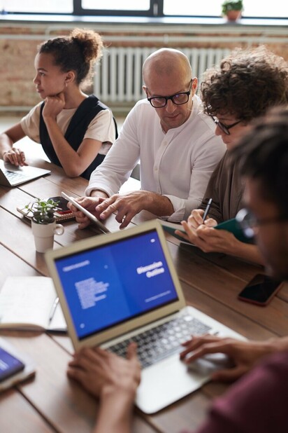 Photo of people working near brown wooden table 3184162